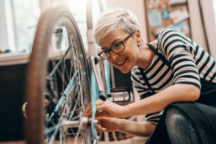 Kvinna reparerar sin cykel